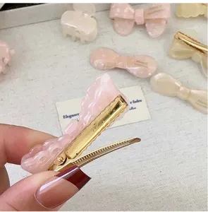 Makrodetail einer rosa Haarklammer aus Essigsäure mit Gelee-Effekt und Goldmetall.