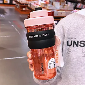 Pink large capacity plastic water bottle with silicone sleeve and portable strap for office.