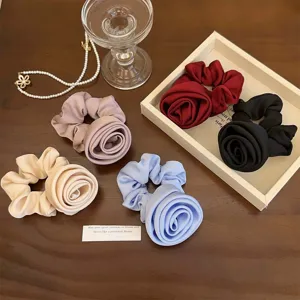 Elegantes Rosenblüten-Haargummi-Set in verschiedenen Farben auf Holzgrund