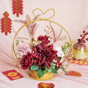 Dettaglio di cesto di fiori in ferro dorato finto con rose rosse e bacche per la decorazione.
