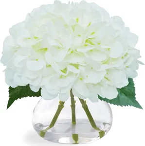 Gros plan d'hortensias blancs artificiels dans un vase en verre avec fausse eau décor.