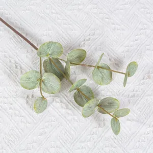 Close-up detail view of artificial eucalyptus leaf branch, showing realistic green foliage.