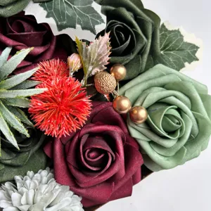 Détail en gros plan des roses artificielles en velours et des composants de boîte florale.
