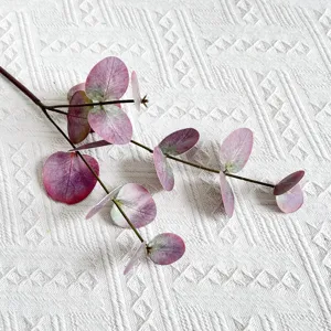 Close-up view of artificial eucalyptus leaf branch featuring realistic purple texture detail.