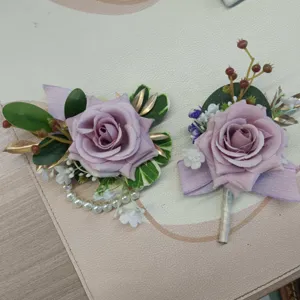 Detail view of purple rose artificial flower wedding corsage and wrist corsage set for decor.