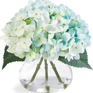 Hortensias artificiels dans un vase en verre transparent avec de l'eau fausse.