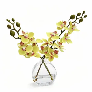 Orchidée phalaenopsis jaune artificielle dans un vase en verre transparent, belle déco bureau.