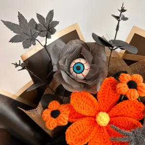 Halloween crochet flower bouquet detail, handmade orange yarn flowers with spooky eyeball.