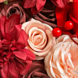 Gros plan détaillé de roses et dahlias en soie artificielle avec baies rouges.