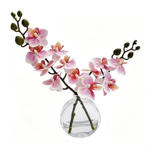 Vue détaillée d'orchidées phalaenopsis artificielles en vase en verre avec eau factice.