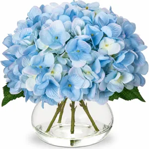 Hortensias bleus artificiels dans un vase en verre transparent avec de l'eau artificielle.