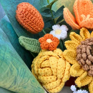Close-up detail of handmade crochet sunflower and rose bouquet, beautiful gift option.