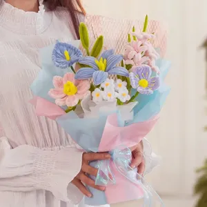 Vista detallada de un ramo de flores hecho a mano con limpiapipas en papel de regalo azul y rosa.