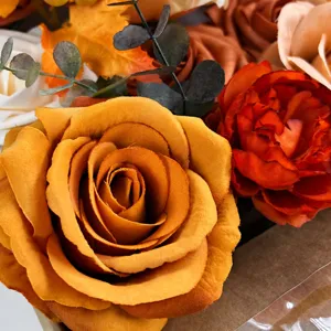 Close up detail of artificial autumn silk roses and maple leaves for DIY floral arrangement.