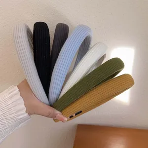 Set of colorful knitted wide headbands held in hand for face washing and styling.