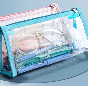 Dettaglio astuccio trasparente impermeabile con bordo blu e articoli di cancelleria.