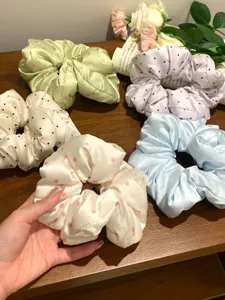 Assortiment de chouchous en satin pastel à pois disposés sur une table en bois