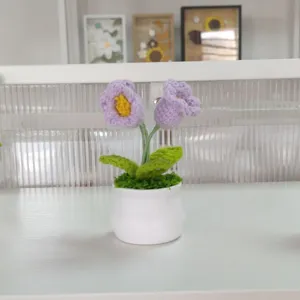Handmade crochet potted flower detail view, beautiful knitted purple floral decor.