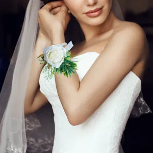 Nahaufnahme Detail künstliche weiße Rosen Handgelenk Corsage mit grünen Blättern an Hand.