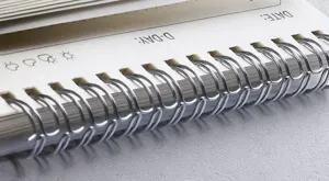 Close-up detail of spiral bound daily planner notebook with metal wire binding and date layout.