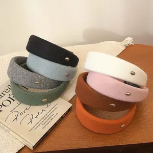 Set de diademas anchas de fieltro de lana en varios colores con etiquetas doradas.