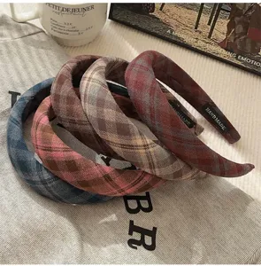 Detailweergave van vier gevoerde haarbanden van retro geruite stof in verschillende kleuren.