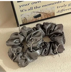 Κοντινή λήψη μεταλλικού γκρι scrunchie με λεπτομέρειες από χάντρες