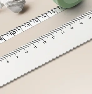 Primer plano detalle de bonita cinta métrica suave y mini con borde festoneado y marcas claras.
