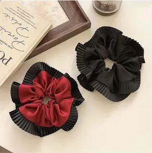 Detailoverzicht van luxe oversized geplooide scrunchies in bordeauxrood en satijn.