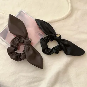 Coppia di eleganti elastici per capelli in ecopelle con fiocco marrone e nero e ciondoli.