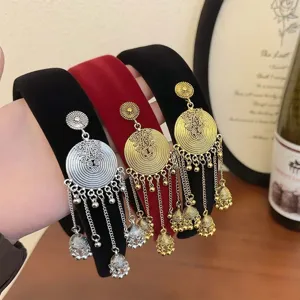 Elegant velvet hairband featuring ethnic gold bell tassels in festive red and black.