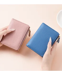 Detailed view of women short wallet, showing lychee grain texture, zipper pocket and card slots.