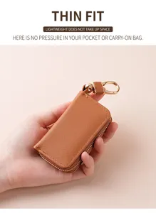Dettaglio astuccio per chiavi in pelle marrone, chiusura lampo, gancio metallico.