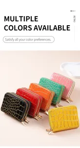 Primo piano di porta carte con cerniera a stampa coccodrillo multicolore e piccoli portafogli.