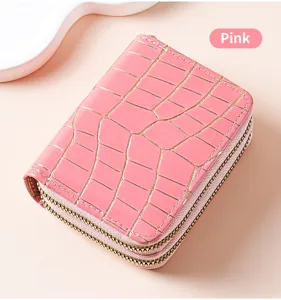 Dettaglio portacarte doppia zip con stampa coccodrillo rosa, piccolo portamonete in pelle.