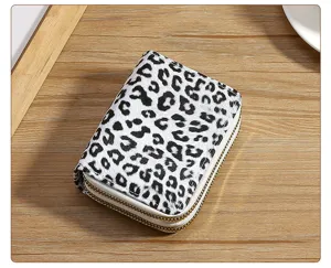 Detail view of a black and white leopard print women's double zipper short coin purse wallet.