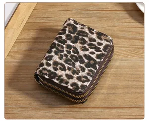 Leopard print double zipper short wallet detail view with fine texture and metal pullers.