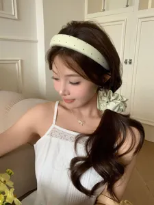 Detailansicht eines cremefarbenen gepolsterten Haarreifs mit Punkten und Scrunchie