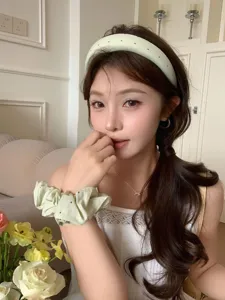 Asiatisches Model mit hellgrünem gepunktetem Schwammstirnband und passendem Haargummi.