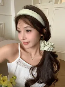 Nahaufnahme eines Models mit cremefarbenem Polka-Dot-Haarreif und passendem Scrunchie