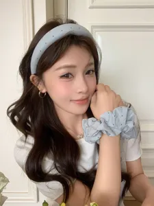 Detailaufnahme eines Models mit hellblauem Polka-Dot-Haarreif und passendem Scrunchie
