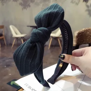 Elegant dark green ribbed fabric bow headband with bunny ears and non-slip inner teeth.