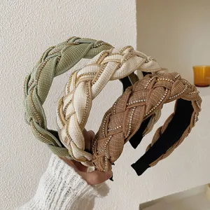 Detail view of three braided headbands with sparkling rhinestone chains in various colors.