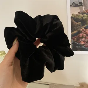 Detailed view of a premium black velvet oversized scrunchie for hair styling.