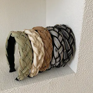 Collection of wide braided headbands with gold chain accents in sage, cream, and tweed.