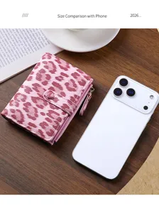 Detailed view of the pink leopard print short bifold wallet showing compact size with phone.