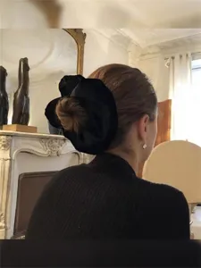Elegant oversized black velvet scrunchie shown in a classic back-view hairstyle detail
