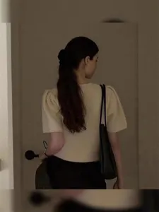 Detail of a black velvet scrunchie on a brunette ponytail, elegant French style fashion look.