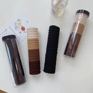 Sets of elastic hair ties in neutral earth tones in transparent cylindrical tubes