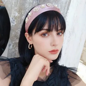 Elegant pink satin headband with pearl and rhinestone flower embellishments on model
